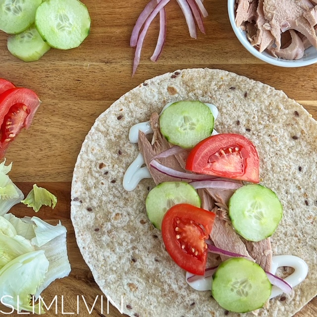 Open Tuna salad wrap on a wooden board